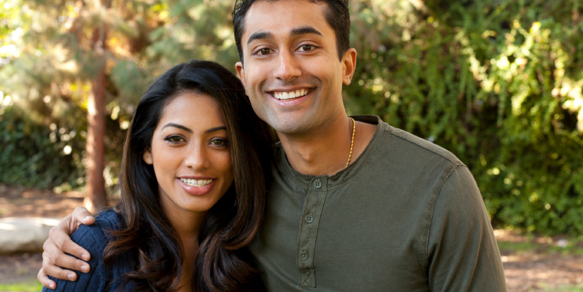 Smiling couple standing outside that is excited that their IRA contributions qualify for the Saver's Credit.