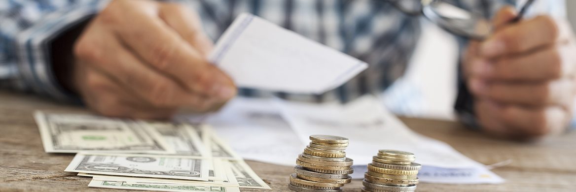A person counting money on a table.