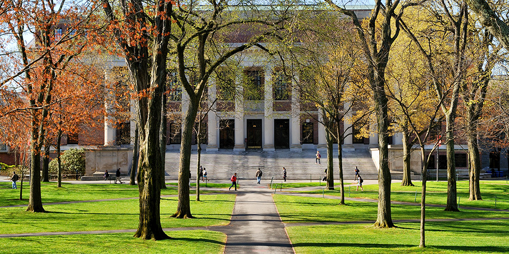 Students who claim education credits walking to class as they pass a college campus university building.