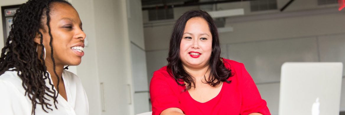 Two people filing taxes on a computer at a free tax filing site.