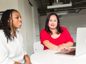 Two people filing taxes on a computer at a free tax filing site.