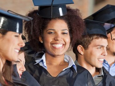 Five smiling college graduates who are happy to decrease their expenses with education tax credits.