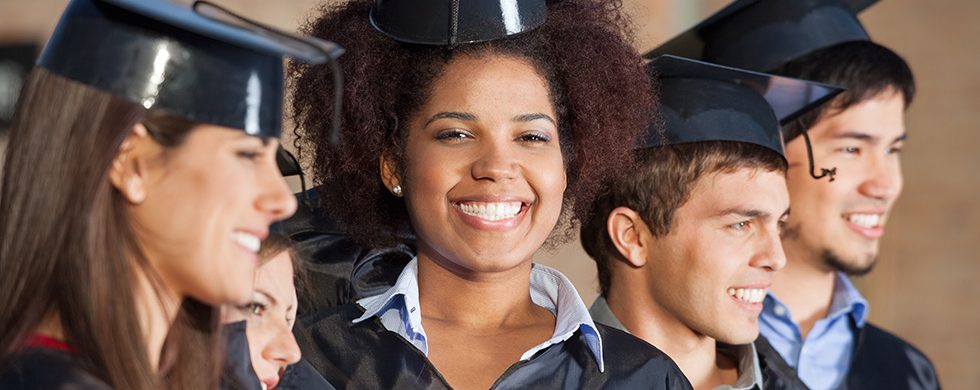 Five smiling college graduates who are happy to decrease their expenses with education tax credits.