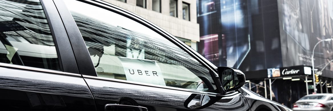 A black car with an Uber sign in the window.