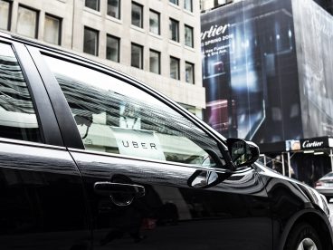 A black car with an Uber sign in the window.