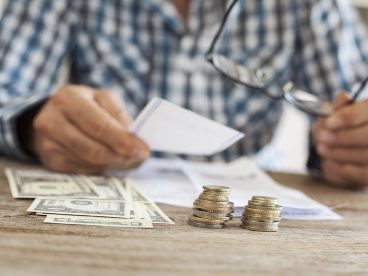 A person counting money on a table.