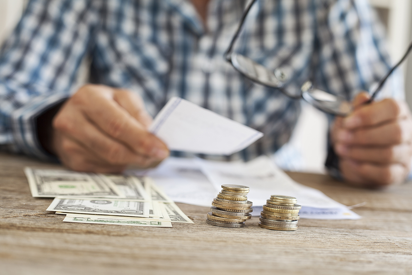A person counting money on a table.