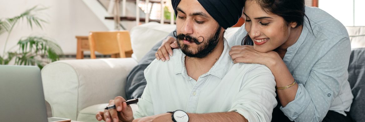 A couple looks at a laptop.