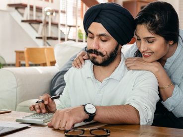 A couple looks at a laptop.