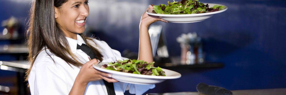 Waitress serving two salads is smiling because she knows she is eligible for the Earned Income Tax Credit.