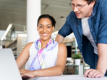 Woman smiles while getting free help to file her taxes on a computer.