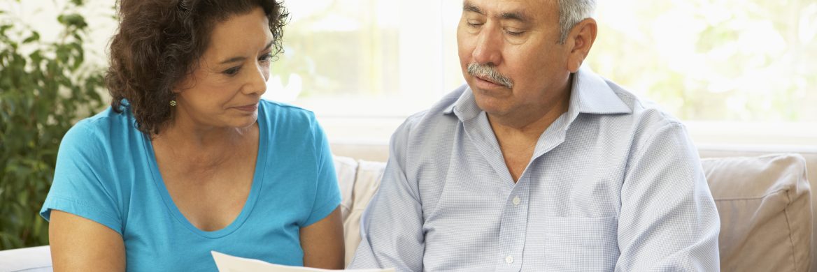 Two people seated on a couch looking at a tax document